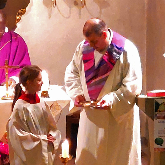 Der Pfarrer und der Pastoralreferent wenden sich der neuen Ministrantin zu. Sie steht in der Mitte.