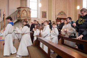 Ministranten mit dem Kreuz voraus ziehen in die Kirche ein