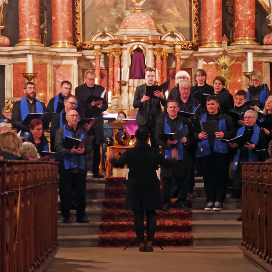 Auf den Altarstufen der Kirche steht ein Chor und singt