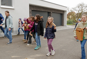 Eine kleine Gruppe an Kindern auf einer Dorfstraße. Sie rappeln und singen.
