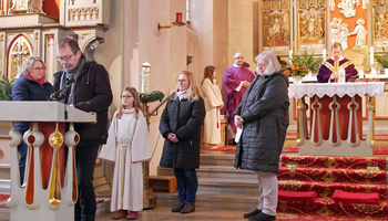 Mehrere Personen stehen am Ambo in der Opferbaumer Kirche